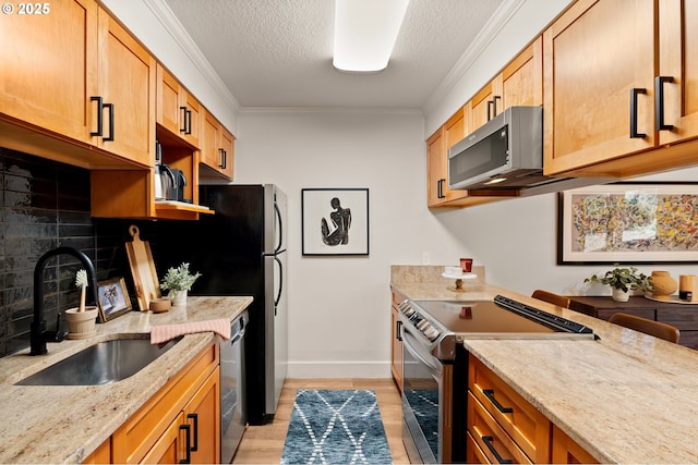 kitchen featuring decorative backsplash, ornamental molding, stainless steel appliances, and a sink