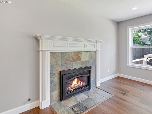 details with a tile fireplace, wood finished floors, baseboards, and recessed lighting