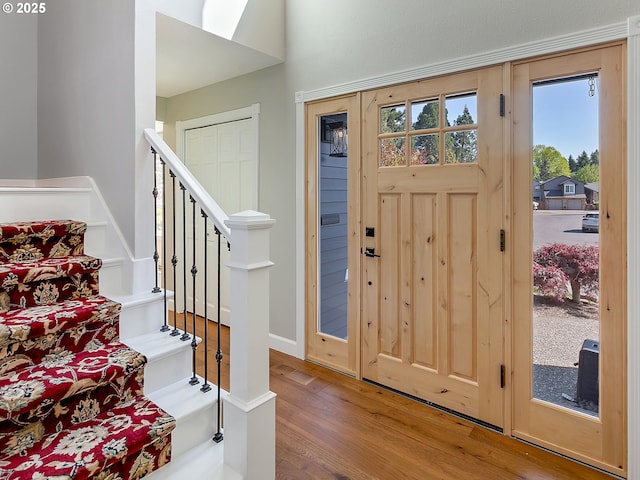foyer entrance with stairway and wood finished floors