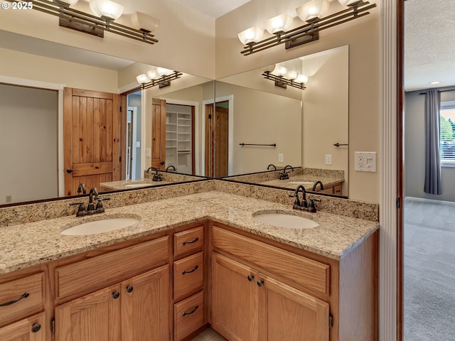 bathroom featuring a sink, double vanity, and a chandelier