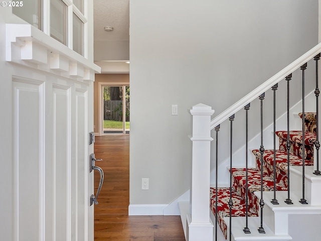 interior space featuring baseboards, stairs, and wood finished floors