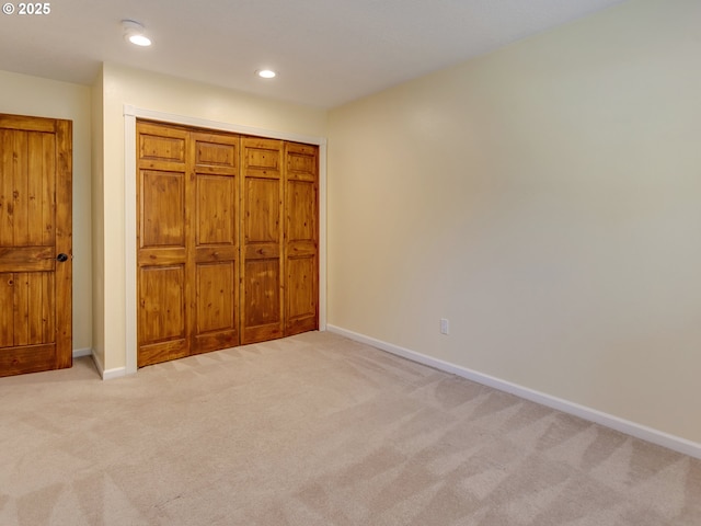 unfurnished bedroom with light carpet, baseboards, and recessed lighting