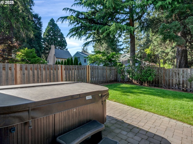 view of patio featuring a hot tub and a fenced backyard