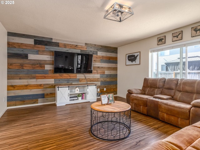 13012 NE 115th St, Vancouver, WA 98682 - living room featuring wooden walls, baseboards, wood finished floors, a textured ceiling, and an accent wall