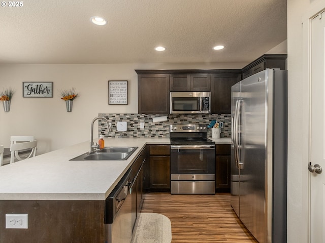 13012 NE 115th St, Vancouver, WA 98682 - kitchen featuring appliances with stainless steel finishes, a sink, dark brown cabinets, light wood-style flooring, and a textured ceiling