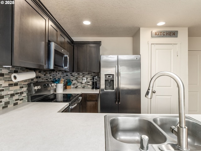 13012 NE 115th St, Vancouver, WA 98682 - kitchen featuring appliances with stainless steel finishes, a sink, dark brown cabinets, light countertops, and a textured ceiling