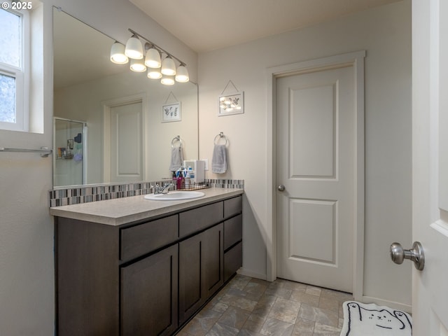13012 NE 115th St, Vancouver, WA 98682 - bathroom featuring vanity, baseboards, stone finish floors, and a shower with shower door