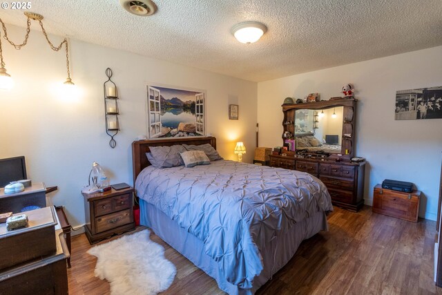 bedroom with hardwood / wood-style floors and a textured ceiling