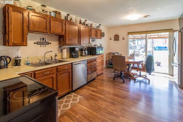 kitchen with sink, light hardwood / wood-style flooring, and black appliances