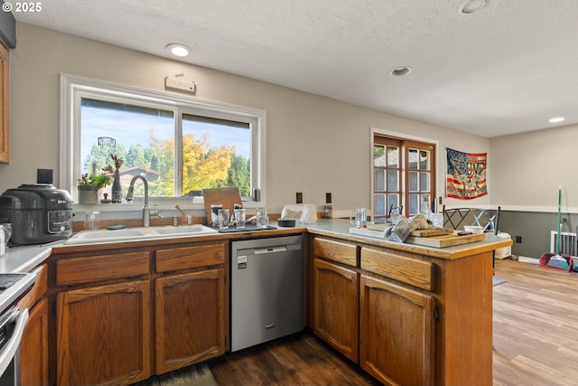 2012 SE Evans Ave, Troutdale, OR 97060 - kitchen featuring stainless steel dishwasher, a peninsula, dark wood-type flooring, light countertops, and recessed lighting