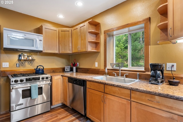 kitchen with stainless steel appliances, open shelves, a sink, and light wood finished floors