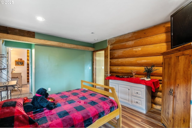 bedroom featuring log walls, recessed lighting, and wood finished floors