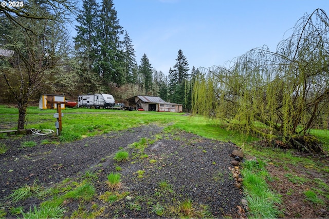 view of yard featuring an outbuilding and a wooded view