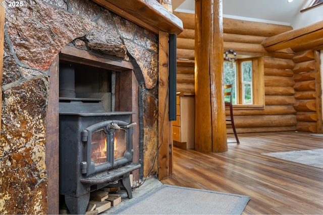 unfurnished living room with rustic walls, wood finished floors, and a wood stove