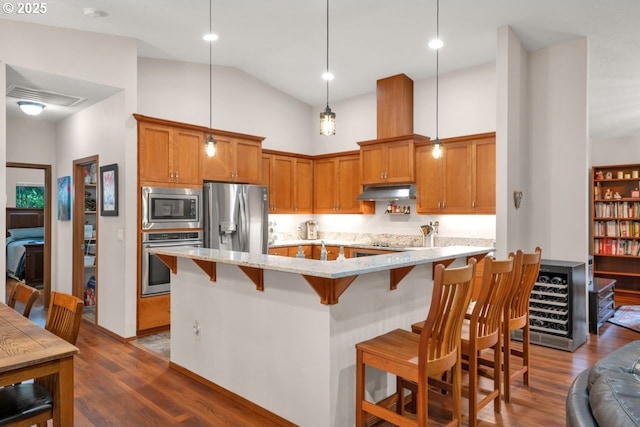 5030 Heceta Park Way, Florence, OR 97439 - kitchen featuring appliances with stainless steel finishes, dark wood-type flooring, high vaulted ceiling, a breakfast bar, and light stone counters