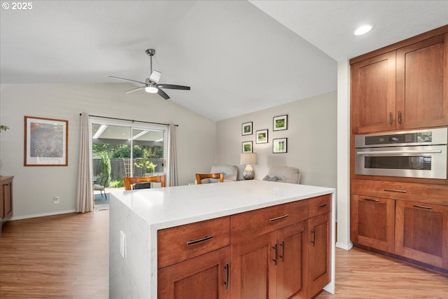 1613 SE Solomon Loop, Vancouver, WA 98683 - kitchen with oven, light wood-style floors, lofted ceiling, ceiling fan, and light countertops