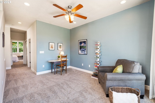 living area with ceiling fan and light carpet