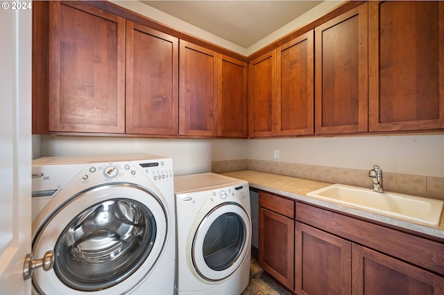 laundry area featuring washer and dryer, cabinets, and sink