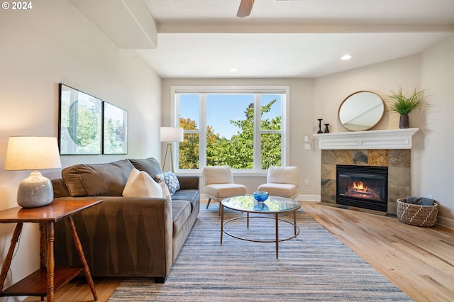 living room with hardwood / wood-style flooring, ceiling fan, and a fireplace