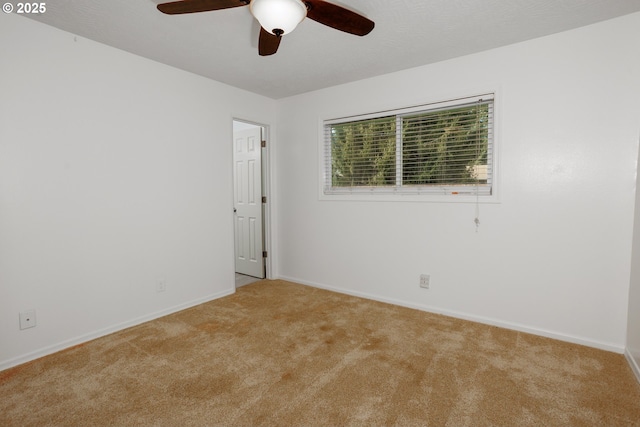 spare room featuring light colored carpet and ceiling fan