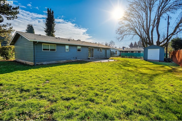 rear view of property featuring a lawn, a patio area, and a storage shed