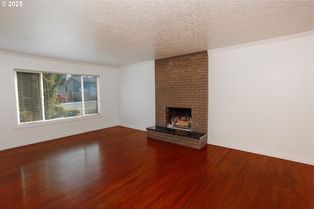 unfurnished living room featuring hardwood / wood-style floors, crown molding, a textured ceiling, and a brick fireplace