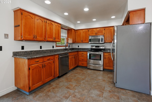 kitchen featuring stainless steel appliances, sink, and dark stone countertops