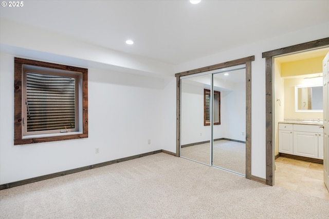 unfurnished bedroom with recessed lighting, light colored carpet, and baseboards