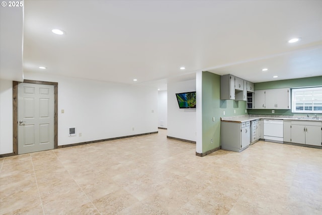 kitchen with recessed lighting, baseboards, white dishwasher, and a sink