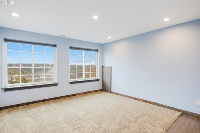 empty room featuring recessed lighting, visible vents, and baseboards