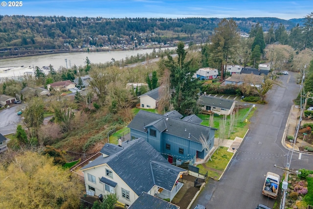 aerial view with a water view and a forest view