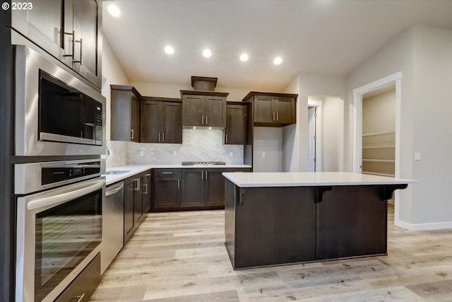 1636 N Millican Crfeek St, Lafayette, OR 97127 - kitchen featuring appliances with stainless steel finishes, dark brown cabinets, light countertops, a center island, and light wood finished floors
