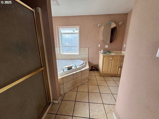 bathroom featuring a shower stall, vanity, a bath, and tile patterned floors