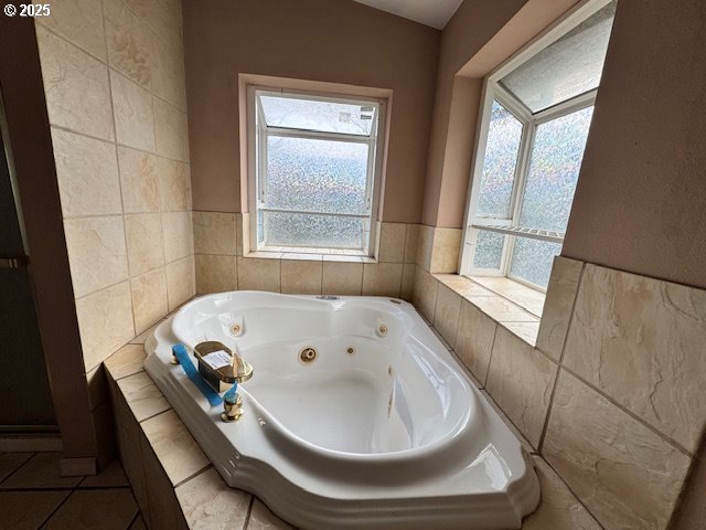 full bathroom with tile patterned flooring and a jetted tub