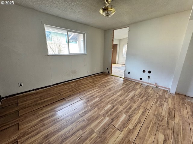 interior space with a textured ceiling and wood finished floors