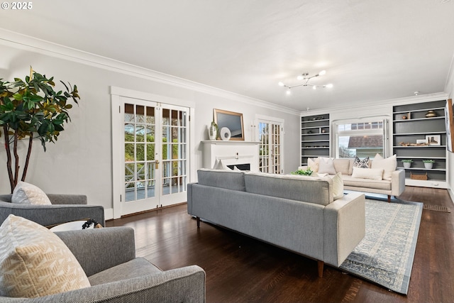 living room featuring crown molding, a notable chandelier, dark hardwood / wood-style flooring, and french doors