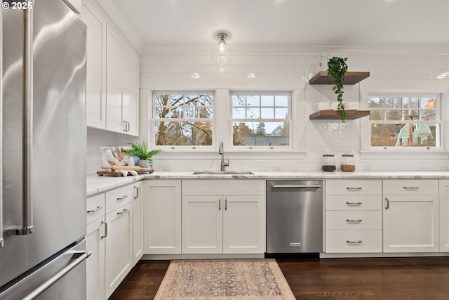 kitchen with stainless steel appliances, a healthy amount of sunlight, sink, and white cabinets