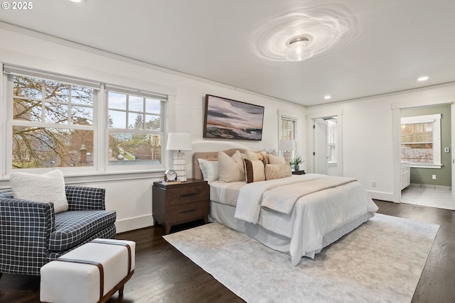 bedroom featuring connected bathroom and dark hardwood / wood-style flooring