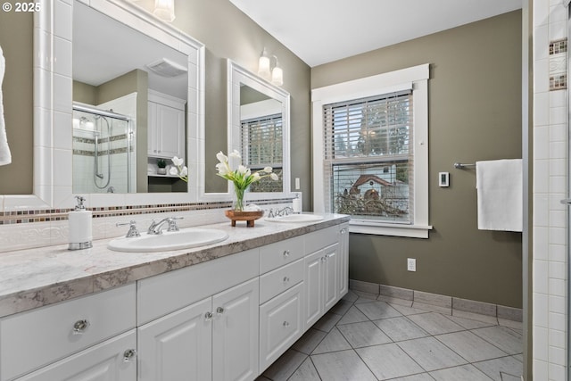 bathroom featuring a shower with door, vanity, and tile patterned floors