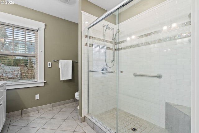 bathroom featuring an enclosed shower, vanity, tile patterned floors, and toilet