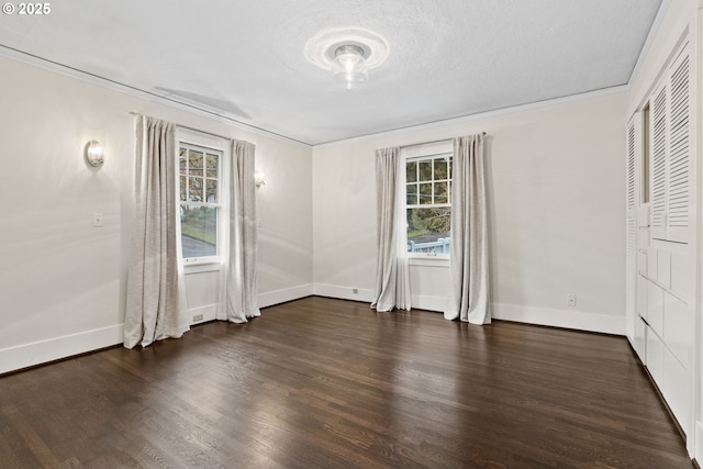 interior space with ornamental molding, a textured ceiling, and dark hardwood / wood-style flooring