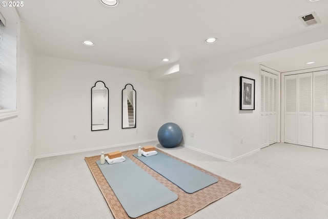 exercise room featuring light carpet