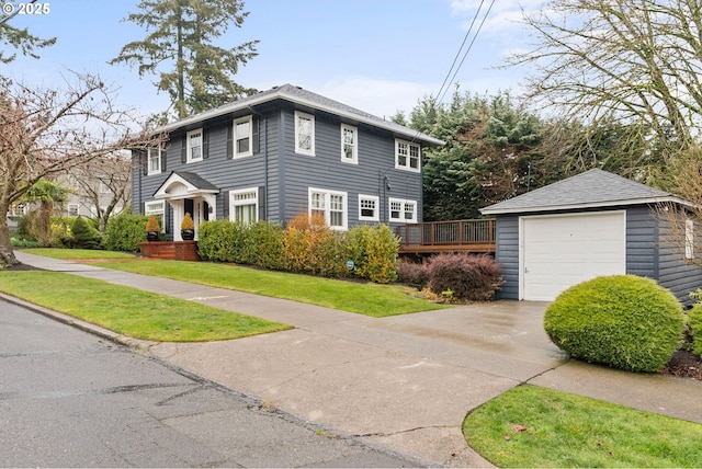 colonial house with a garage, a wooden deck, an outdoor structure, and a front yard