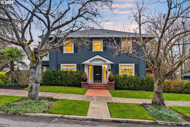 colonial-style house featuring a lawn