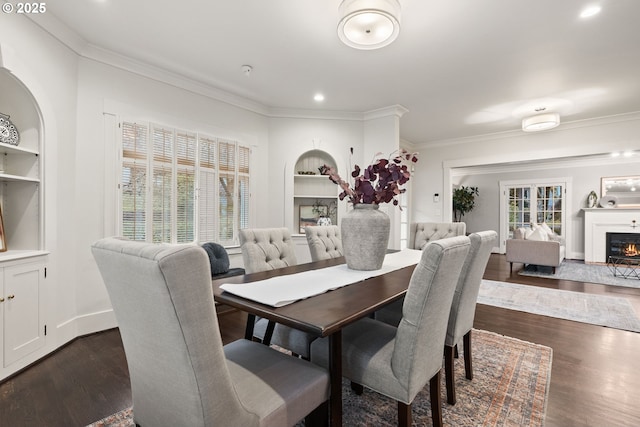 dining room with ornamental molding, dark hardwood / wood-style floors, and built in shelves