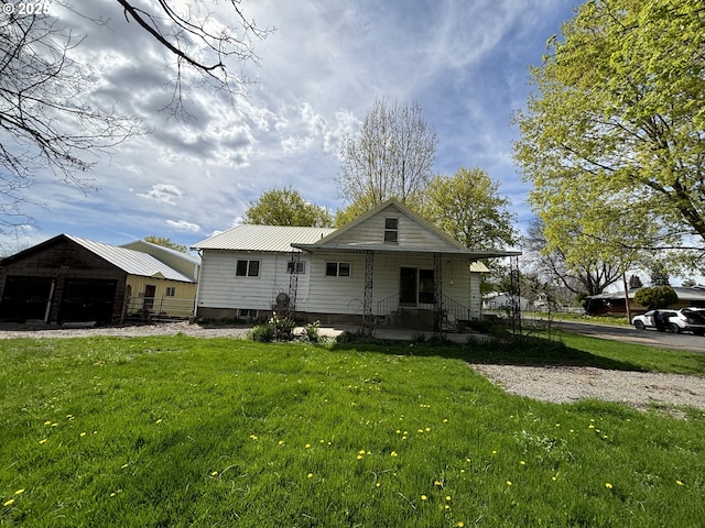410 Division St, Elgin, OR 97827 - view of front facade featuring a detached garage, metal roof, an outdoor structure, and a front yard