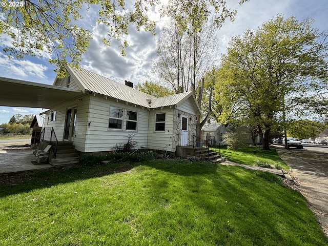 410 Division St, Elgin, OR 97827 - view of property exterior with a lawn, a chimney, and metal roof