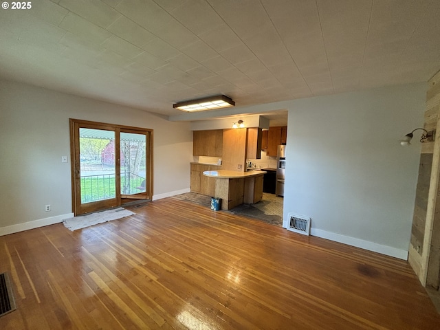 410 Division St, Elgin, OR 97827 - unfurnished living room with visible vents, baseboards, and hardwood / wood-style floors