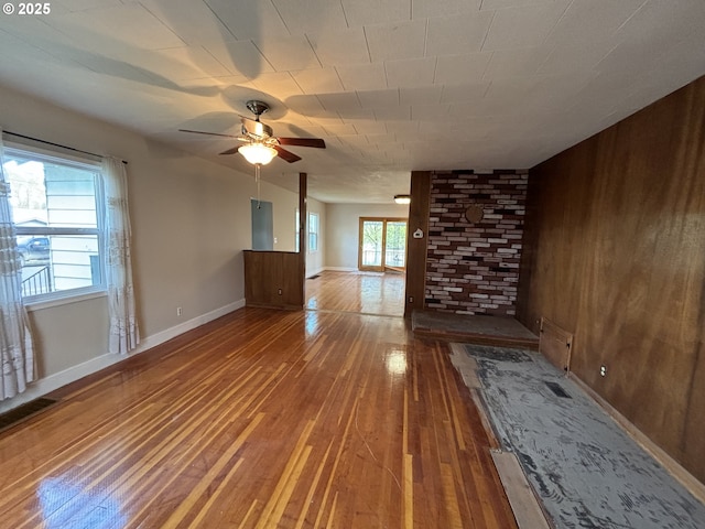 410 Division St, Elgin, OR 97827 - unfurnished living room with wooden walls, baseboards, ceiling fan, and wood-type flooring