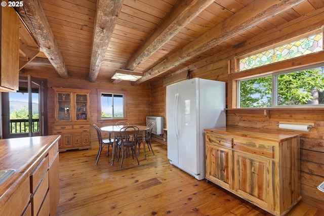 35912 Valley View Ln, Halfway, OR 97834 - kitchen with freestanding refrigerator, wooden ceiling with exposed beams, wood walls, and light wood-style floors